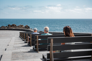 Group of Lonely Mature Old People Sitting Alone on Benches by the Sea, Each Lost in Their Own...