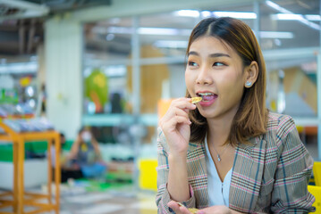 Beautiful asian young beautiful business woman acting to eat whi