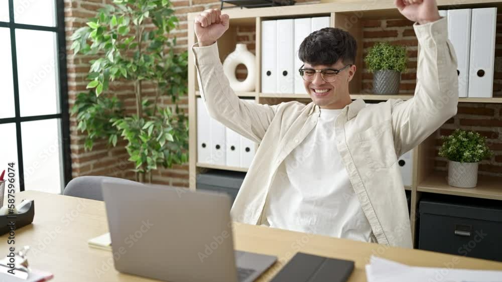 Sticker Young hispanic man business worker using laptop working with winner expression at office