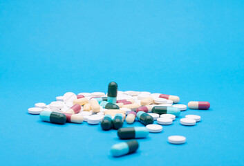 green capsule pill on blue background table medicine vitamin antibiotic and medical treatment of...