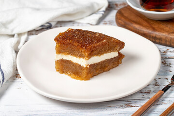 Bread pudding on wood floor. Traditional Ramadan dessert. Bread kadayif with cream in the middle. Local name kaymaklı ekmek kadayifi