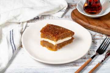 Bread pudding on wood floor. Traditional Ramadan dessert. Bread kadayif with cream in the middle. Local name kaymaklı ekmek kadayifi
