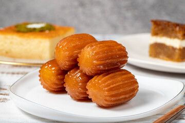 Güllaç, revani, tulumba and bread kadayif dessert with cream on a wood floor. Ramadan sweets. Traditional Turkish cuisine delicacies. Close up