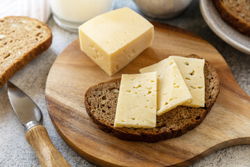 Healthy food concept, breakfast, superfood. Fresh whole grain bread with cheese and a glass of almond milk on stone table.