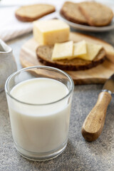 Healthy food concept, breakfast, superfood. Glass of almond milk and fresh whole grain bread with cheese on stone table.