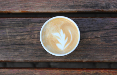 Cappuccino Cup With Flower Pattern On A Foam On A Wood Planks  
