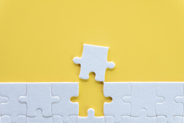 Top view photo of a white jigsaw puzzle over yellow background use for Flat lay top view mock-up...