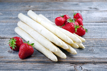 Reife rote Erdbeeren und weißer Spargel aus biologischem Anbau angeboten als close-up auf einem...