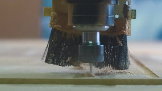 Cnc machine cuts squere wood close-up