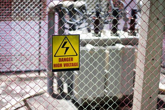 High voltage hazard sign on steel grid in dangerous areas