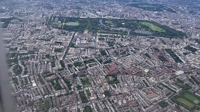 Plane flight over central London with view of Parliament, London eye, Westminster bridge, park, Thames river and Buckingham palace
