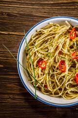 Spaghetti with chili and olive oil on wooden background