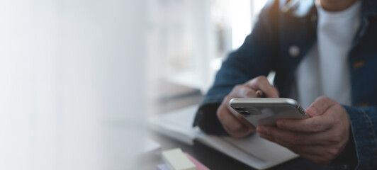 Business woman hand using mobile phone, typing on smartphone screen during planning work with...