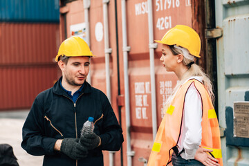 White american man and woman worker construction co-workers discussing about work plan construction site working at container yard.