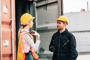 White american man and woman worker construction co-workers discussing about work plan construction site working at container yard.