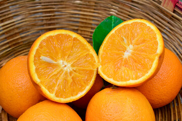 Ripe Orange fruit in a basket on a wooden surface