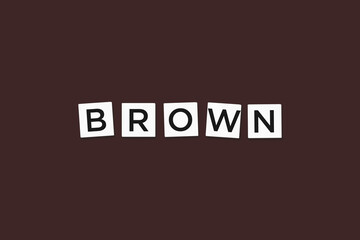 The word BROWN, spelt with letter Scrabble tiles on a brown background