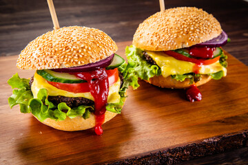 Big cheeseburgers on wooden board
