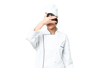 Young caucasian chef  woman over isolated chroma key background covering eyes by hands and smiling