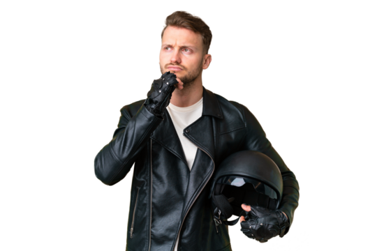 Young caucasian man with a motorcycle helmet over isolated chroma key background and looking up