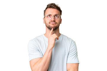 Young handsome caucasian man over isolated chroma key background With glasses and looking up