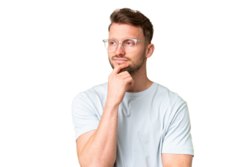 Young handsome caucasian man over isolated chroma key background With glasses and having doubts