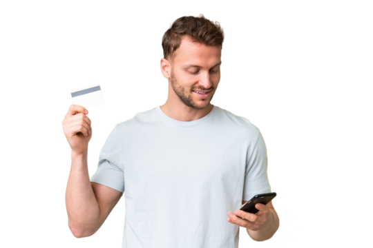 Young handsome caucasian man over isolated chroma key background buying with the mobile with a credit card