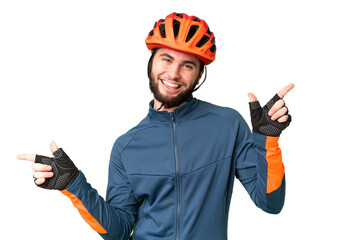 Young cyclist man over isolated chroma key background pointing finger to the laterals and happy