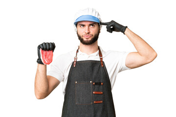 Butcher man wearing an apron and serving fresh cut meat over isolated chroma key background having doubts and thinking