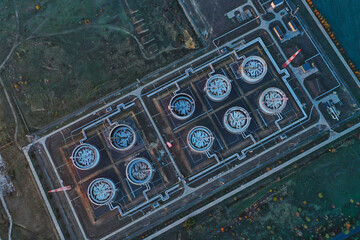 A top-down aerial view of rows of oil tanks connected by pipes in an oil refinery. Bird's eye view...