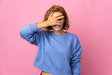 Young Georgian woman isolated on pink background covering eyes by hands and smiling