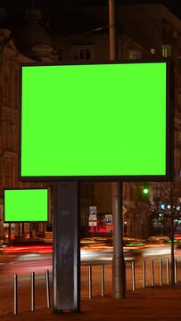 Vertical Screen: timelapse of two green screen billboards with night traffic. lightbox with chroma key on city street at night . Concept commercial public information and advertising marketing