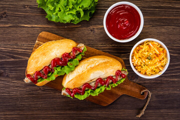Hot dogs, coleslaw and ketchup on wooden table

