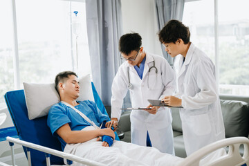 Obraz premium Hospital Ward Male and Femle Professional Asian Doctors Talk with a Patient, Give Health Care Advice, Recommend Treatment Plan with Advanced Equipment .