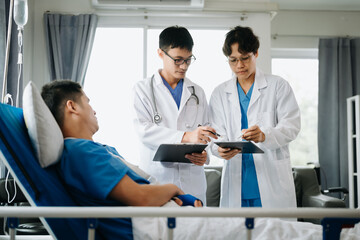Fototapeta premium Hospital Ward Male and Femle Professional Asian Doctors Talk with a Patient, Give Health Care Advice, Recommend Treatment Plan with Advanced Equipment .