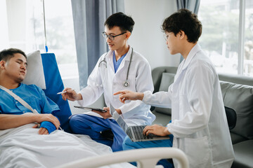 Obraz premium Hospital Ward Male and Femle Professional Asian Doctors Talk with a Patient, Give Health Care Advice, Recommend Treatment Plan with Advanced Equipment .