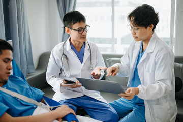 Hospital Ward. Doctor Talks With Professional Head Nurse or Surgeon, They Use Digital tablet Computer. Diverse Team of Health Care Specialists Discussing Test Result in hospital