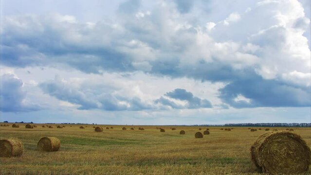 Landscape with harvested bales of straw in field, timelapse 4k
