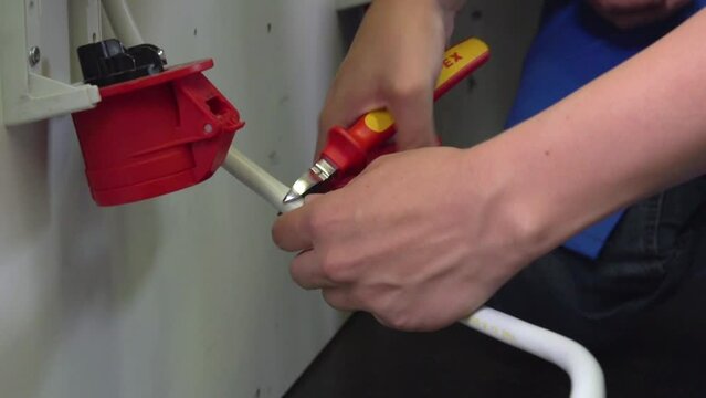 female apprentice cutting power current cable