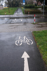 Bike path crosses car road in pouring rain