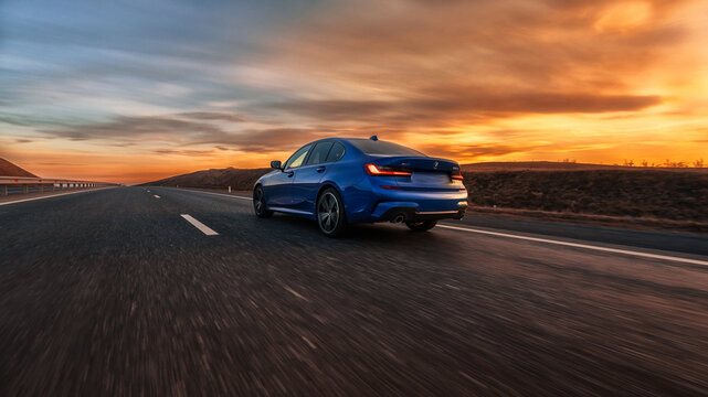 Seattle, Washington, USA March 31, 2023 blue BMW 320 with M Performance package. a car on the road at sunset. rear view