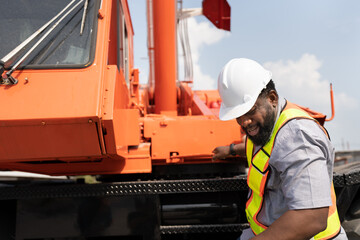 African American Engineer man with crane truck background at site work	