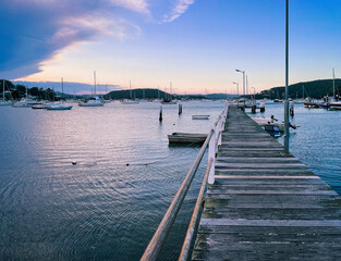 Seascape perspective at sunset in the small resort town of Killcare with the pier and marina in the foreground on the Central Coast, NSW, Australia.