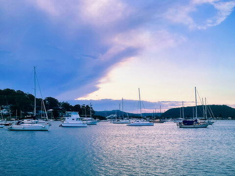 Beautiful scenery at sunset in the small resort town of Killcare with boats on the water in the foreground on the Central Coast, NSW, Australia.