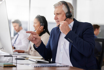 Man, call center and pointing to computer in office while working on customer service in workplace. Telemarketing, focus and mature person, male sales agent or consultant talking or consulting online
