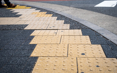 Japanese Yellow Tenji Blocks or tactile paving at a road crossing, Tokyo, Japan
