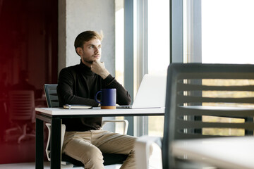 Portrait of attractive businessman, using laptop, man working online, looking away