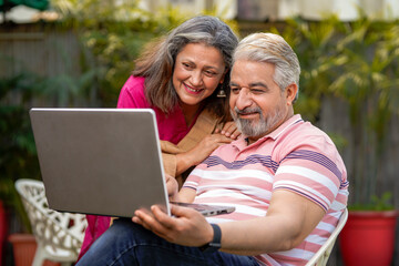 Fototapeta premium Indian senior couple using laptop. technology concept.