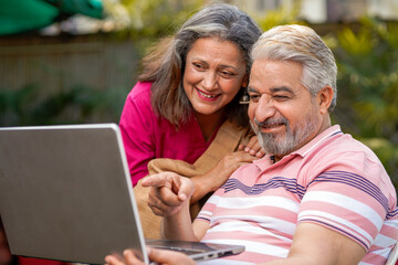 Indian senior couple using laptop. technology concept.
