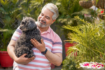 Indian senior man love with dogy puppy. concept about pets and animals.